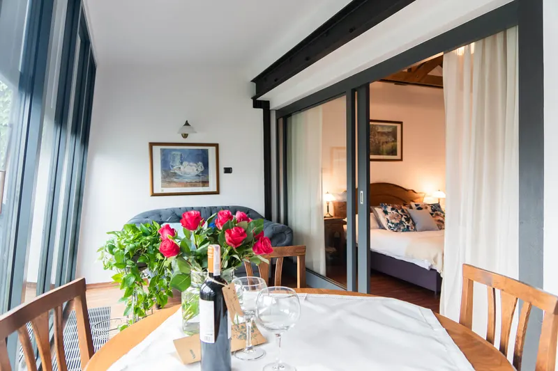 Table with flowers and a view into the bedroom — Deluxe Apartment, Hornigold