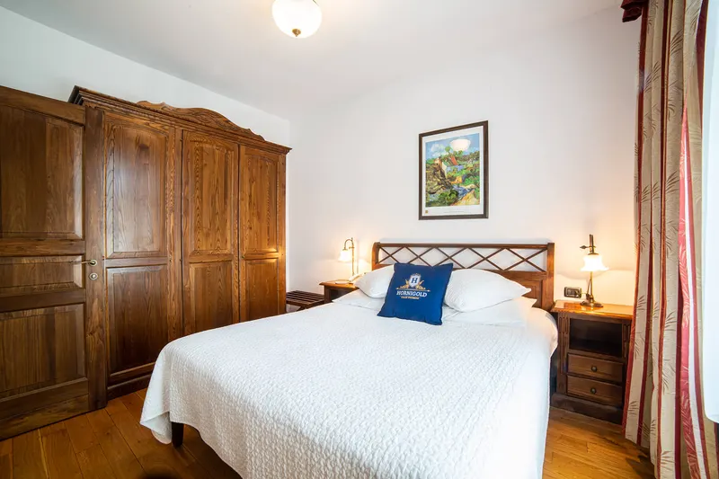 Cama junto a un armario de madera — Deluxe, Hornigold