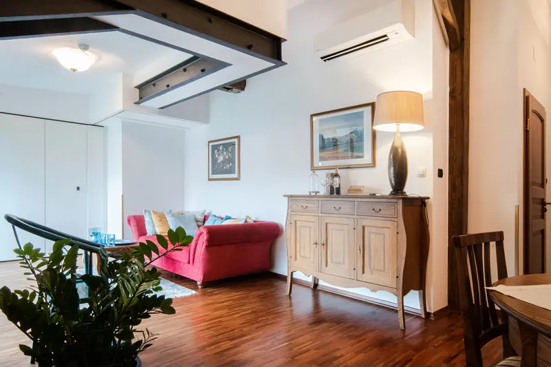 Wohnzimmer mit Holzbalken, rotem Sofa und Kommode — Apartment Hornigold, Hornigold