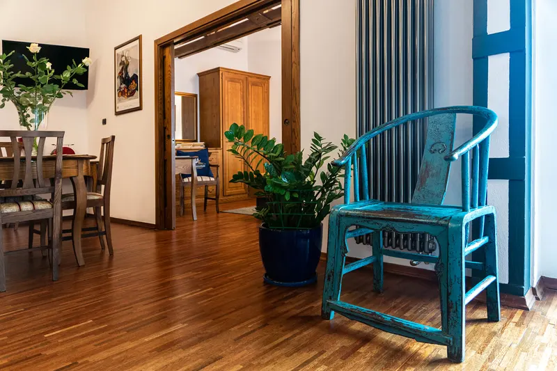 Silla azul junto al ventanal y salón al fondo — Apartamento Hornigold, Hornigold