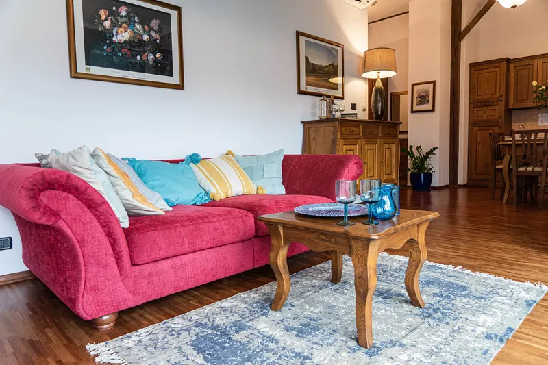 Sofá rojo y mesa de centro de madera en el salón — Apartamento Hornigold, Hornigold