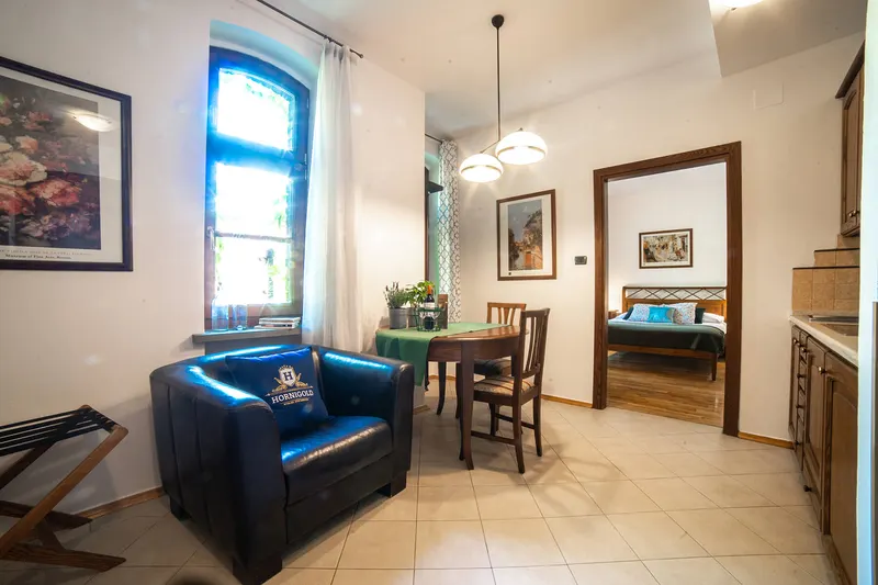 Poltrona blu, tavolo e ingresso della camera — Premium, Hornigold