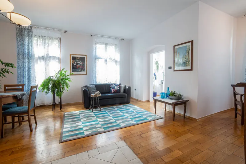 Wohnzimmer mit Sofa, Pflanzen und geometrischem Teppich — Apartment Prestige, Hornigold