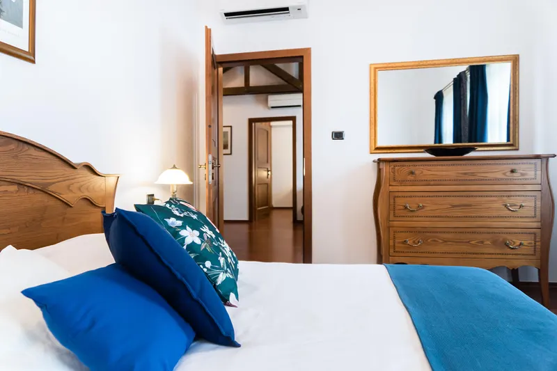 Bett, Spiegel und Holzkommode — Apartment Prestige Deluxe, Hornigold