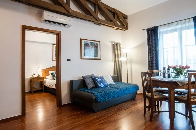 Living room with a blue sofa, table and wooden beams — Prestige Deluxe Apartment, Hornigold