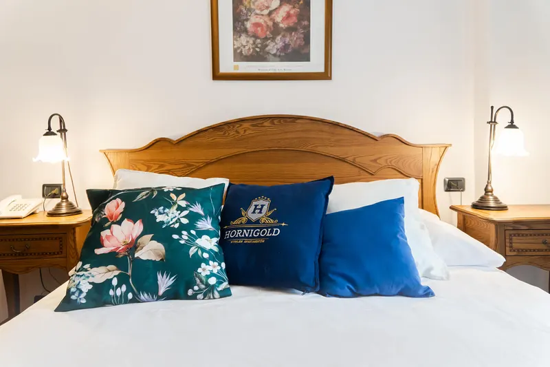 Close-up of cushions and the wooden headboard — Prestige Deluxe Apartment, Hornigold