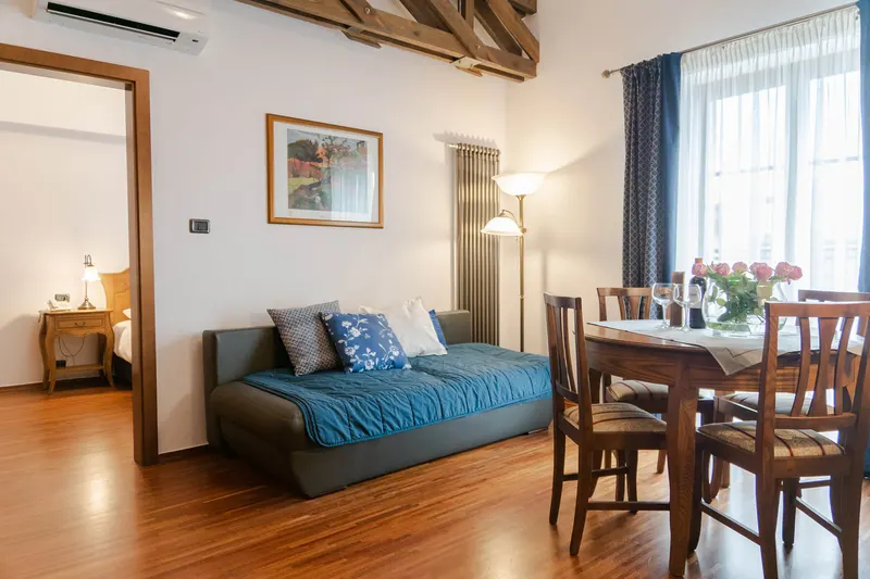 Living room with a blue sofa, table and wooden beams — Prestige Deluxe Apartment, Hornigold