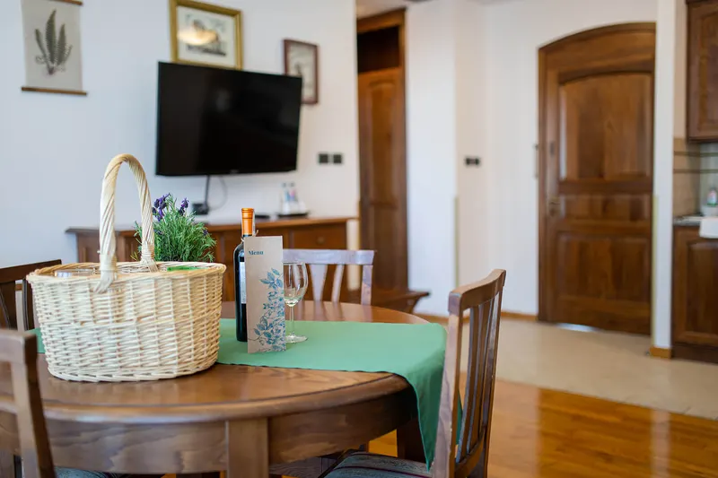 Tisch mit Stühlen, Dekoration und Fernseher im Hintergrund — Suite, Hornigold